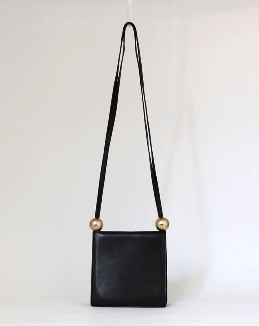 structured bag in black leather with metal spheres