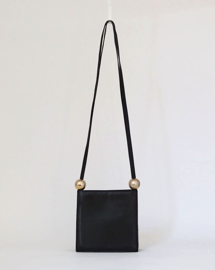 structured bag in black leather with metal spheres