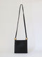 structured bag in black leather with metal spheres